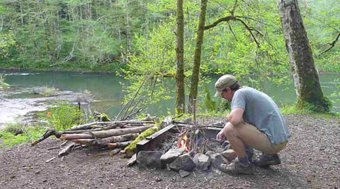 Man Starting Fire at Camp Stock Footage 22917250