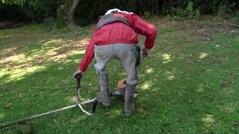 Man Starting Gas Powered Brush Cutter Engine in Garden Video stock 328490901
