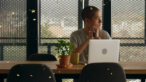 Man starting laptop work, clasping chin, glancing at mesh window while gold Stock Footage 333477785