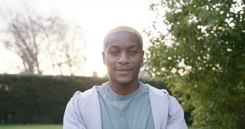 Man starting looking up in garden turning to camera smiling, relaxing in gray Stock Footage 344668778