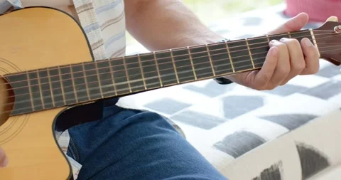 Man is starting right strum, shifting left and picking cutaway guitar by window, Stock Footage 340773836