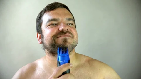 Man starting to shave beard with razor machine. 動画素材 96479798