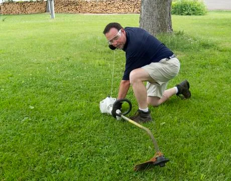 Man Starting A String Trimmer Stock Photos