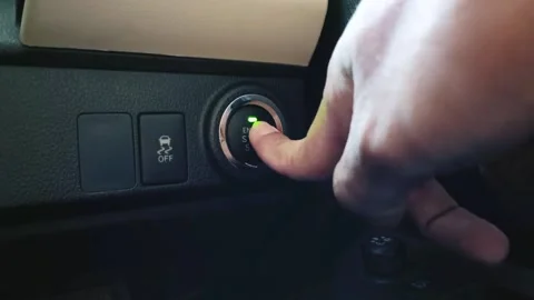 A man starts the car engine by pressing the car's engine start stop button Stock Footage 313574657