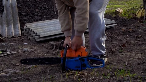 The man starts a chainsaw, a chainsaw with a two-stroke engine Stock Footage 120253355