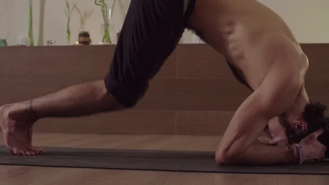 Man starts doing difficult yoga pose - head standing balance Video stock 105911987