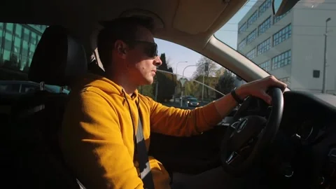 Man starts driving car intersection city He puts down phone, makes start Stock Footage 153867098