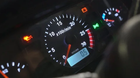 A man starts a new small tractor. The dash panel lights up. Engine speed Stock Footage 128635900