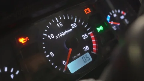 A man starts a new small tractor. The dash panel lights up. Engine speed Stock Footage 128636111