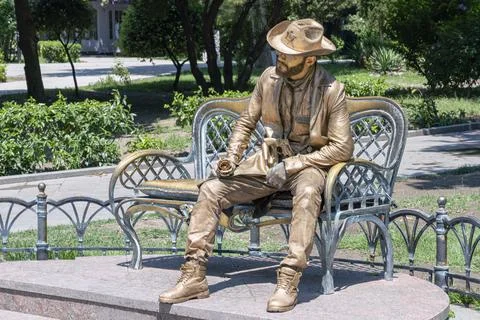 A man-statue is sitting on a bench 스톡 사진