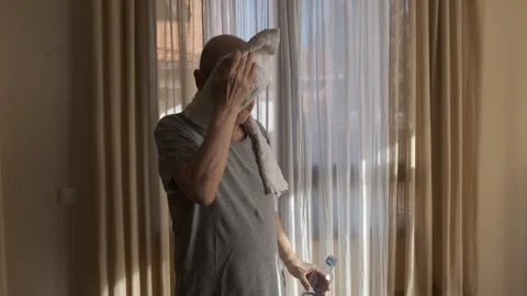 Man Staying Hydrated After Exercise in Sunlit Interior Setting Stock Footage 305569572