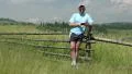 Man staying near wooden fence, holding telephone, smiling and gestures HD Footage