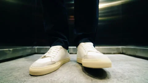 Man stays inside elevator tapping foot on metal floor Stockbeeldmateriaal 280907239