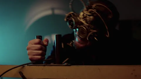 A man with a steampunk mask operating a machine Vídeo Stock 259857542