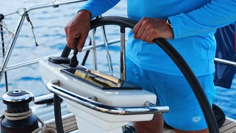 Man steering a sailing yacht using navigation display and control panel near Stock Footage 313218418