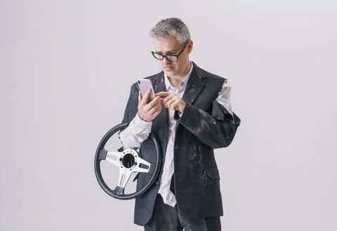 Man with steering wheel using smartphone for roadside assistance Stock Photos