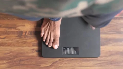 Man stepping on digital weighing scale, measuring body weight, top down ind.. Stock-Footage 332469706