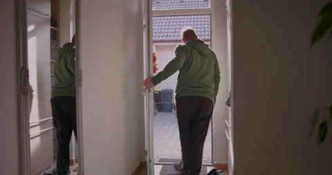 Man stepping outside through front door, leaving home for a casual outing, .. Vídeo Stock 293221553