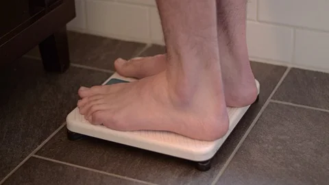 Man stepping on scale weight loss Stock Footage 129965982