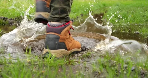 Man steps into a muddy puddle and that step makes mud splashing Stock Footage 196827561