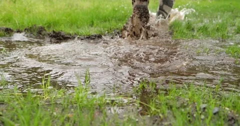 Man steps into a muddy puddle and that step makes mud splashing Stock Footage 196827563