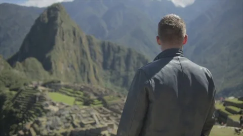 Man steps out onto Machu Picchu look out point, and enjoys the accomplishment. Stock Footage 82329006