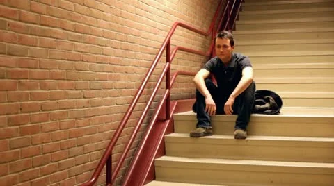 Man on steps put on jacket and walks away Vidéo 10713008