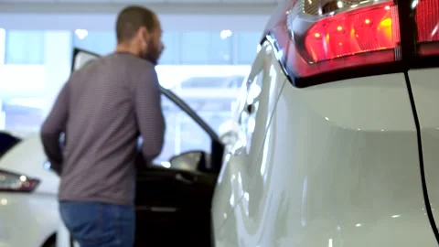 Man steps into a stylish crossover at the dealership Stock-Footage 311945977
