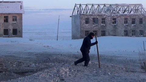Man with a stick walking in the snow Stock Footage 99504061