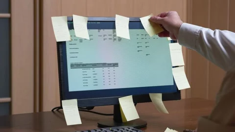 Man sticking post it reminders on her desktop monitor Stock-Footage 320542659