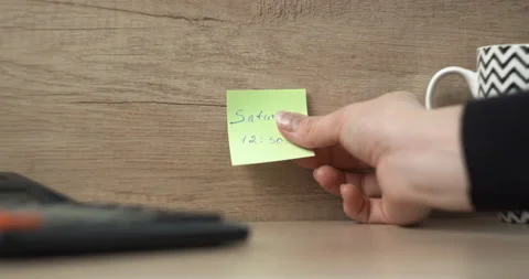 Man sticks a sticker with a note about the day of the week Stock Footage 146360500