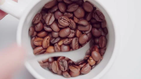 Man stirring coffee beans in a mug with a spoon. Stock Footage 143538972