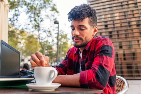 Man stirring coffee with a spoon while working Stock Photos