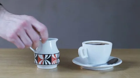 A Man Stirring Into a Cup With a Teaspoon Stock Footage 69163195