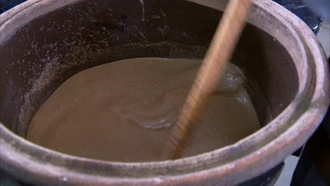 Man stirring liquid into huge container Stockbeeldmateriaal 88334272