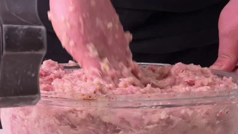Man stirring minced meat from a meat grinder, side view Vidéo 304793594
