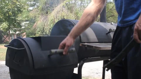 Man Stirs Coal In A Grill Stock Footage 61196673