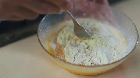 Man stirs eggs with flour Stock Footage 79110577