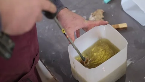 Man stirs epoxy, a process in creating durable finishes. Symbolizes the DIY Stock Footage 257009487