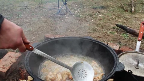 A man stirs fried potatoes in a cauldron. Close-up Stock-Footage 332441802