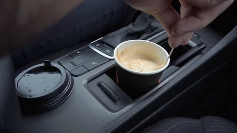 The man stirs his coffee in paper cup Stock Footage