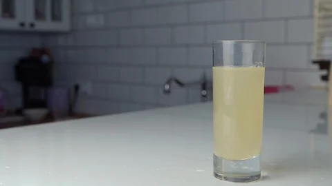 A man stirs the medicine with a spoon in a glass of water Stock Footage
