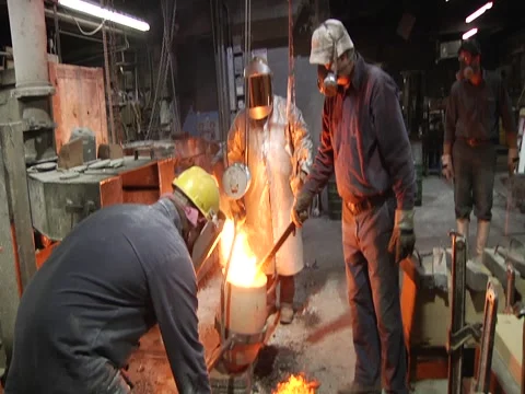 Man Stirs Molten Metal/ Fire Shoots Up Stock Footage 1089656