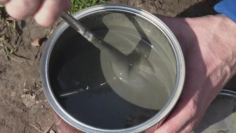 A man stirs paint in a jar Stock Footage 275598445