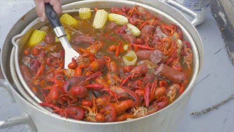 Man Stirs Pot of Boiling Crawfish with a Spatula Stock Footage 74987950