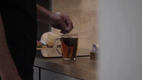A man stirs sugar in a mug of tea Stock Footage 254166181