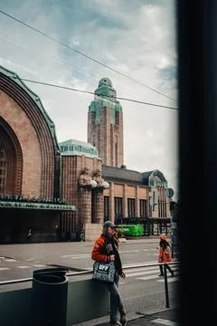 Man stood underneath Helsinki central train station clock tower in autumn Stock Photos