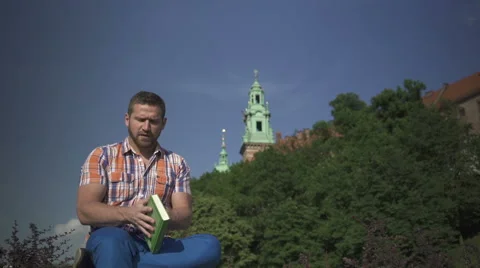 Man stops reading book and looking round. Vidéo 52698357