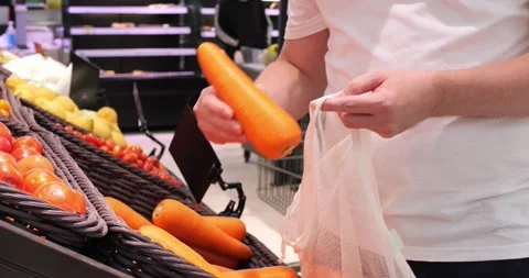 Man in store buys carrots to prepare delicious dinner for whole family from Stock Footage 226399085