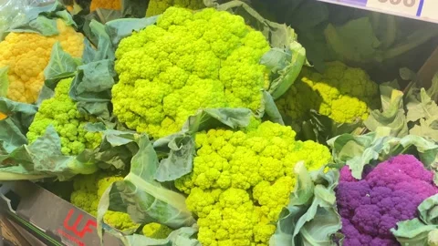 Man in a store chooses a beautiful broccoli cauliflower in the refrigerator Stock Footage 203970674